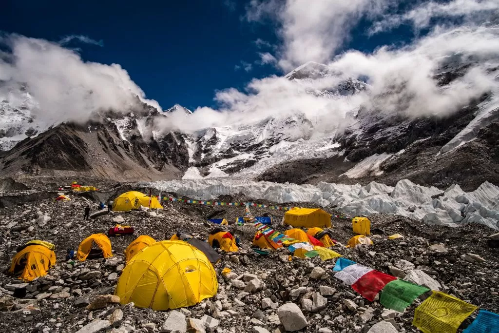 View of trekkers at Himalaya Base Camp surrounded by snow-covered peaks and glaciers
